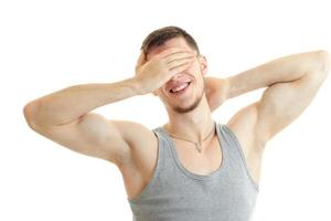 guy stands in front of the camera, smiles and closes the hand face photo