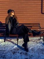 señora glamurosa se sienta en el banco al aire libre foto