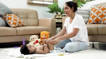 azione video clip di madre esercizio sua bambino mentre massaggiare.