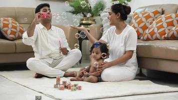 Video footage of Indian dad blowing bubbles and baby enjoying it.