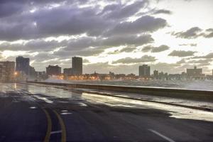 Evening at the seaside drive Malecon in Havana, Cuba as the waves crash over. photo