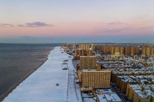 vista aérea de una playa de Coney Island cubierta de nieve durante el invierno al amanecer en Brooklyn, Nueva York foto