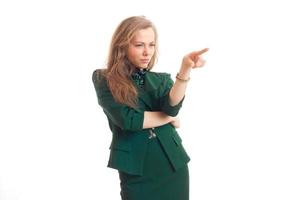 Beautiful blonde business lady in green uniform pointing aside photo