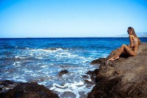 sexy girl in a stunning blue sea photo