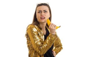 Portrait of funny beautiful lady in glamorous gold jacket and a banana in her hand photo