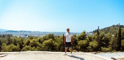 stylish guy stands above the forest on the mountain photo