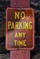 Old rusted No Parking Any Time street sign. photo