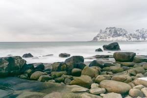 olas que fluyen sobre la playa de utakleiv, islas lofoten, noruega en el invierno. foto