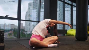 vrouw die zich uitstrekt in de sportschool video