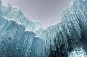 Translucent blue icicles in a frozen ice wall. photo