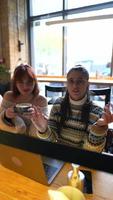 jeunes femmes dans un café parlant et utilisant un ordinateur portable video