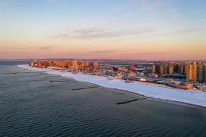 vista aérea de una playa de Coney Island cubierta de nieve durante el invierno al amanecer en Brooklyn, Nueva York foto