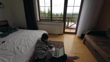 Woman uses laptop on bedroom floor video