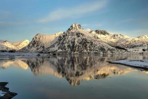 montañas reflejadas en un lago en flakstadoya en las islas lofoten, noruega foto