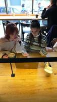 Young women in a cafe talking and using laptop video