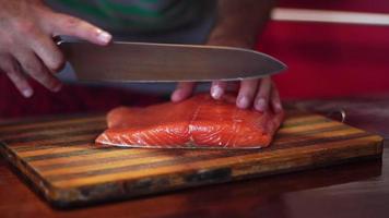 man cuts salmon close up video