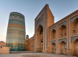 Kalta Minor Minaret and the historic architecture of Itchan Kala, walled inner town of the city of Khiva, Uzbekistan a UNESCO World Heritage Site. photo