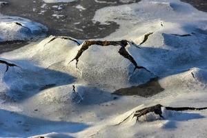 roca que se agrieta a través del hielo en boosen en las islas lofoten, noruega en el invierno. foto