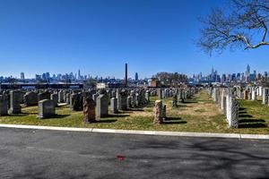 New York City - Feb 23, 2020 -   Calvary Cemetery with Manhattan skyline in New York. Calvary Cemetery is a cemetery in Queens, containing more than 3 million burials. photo