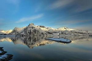 montañas reflejadas en un lago en flakstadoya en las islas lofoten, noruega foto