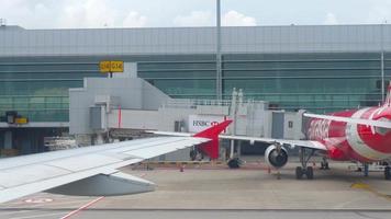 Changi, Singapore 22 november 2018 - Terminal 4 in Changi Airport uitzicht vanaf taxiënd vliegtuig Airasia, vliegtuigen geparkeerd in de buurt van terminal. video