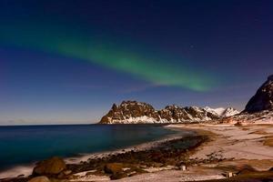 Northern lights over the sea at Utakleiv Beach, Lofoten Islands, Norway in the winter. photo