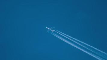 contrails in de blauwe lucht. vliegtuig dat hoog vliegt. video