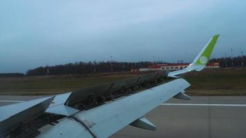 Airplane wing with open hydraulics in aileron position, landing, spoilers raised. Flaps in landing position. The wing slats are extended for braking when landing at the airport. video