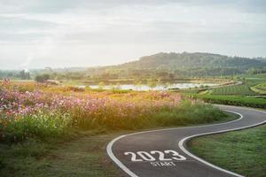 Happy new year 2023,2023 symbolizes the start of the new year. The letter start new year 2023 on the road in the nature fresh green tea farm mountain environment ecology or greenery wallpaper concept. photo