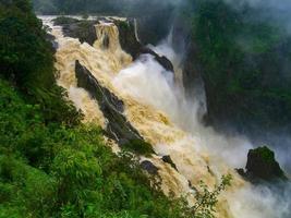 The Barron Falls s a steep tiered cascade waterfall on the Barron River located where the river descends from the Atherton Tablelands to the Cairns coastal plain, in Queensland, Australia. photo