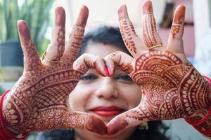 hermosa mujer vestida como tradición india con diseño de henna mehndi en ambas manos para celebrar el gran festival de karwa chauth, celebraciones de karwa chauth de una mujer india para su marido foto