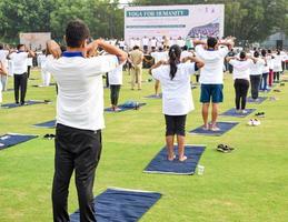 Group Yoga exercise session for people of different age groups at cricket stadium in Delhi on International Yoga Day, Big group of adults attending yoga session photo