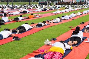 Group Yoga exercise session for people of different age groups at cricket stadium in Delhi on International Yoga Day, Big group of adults attending yoga session photo