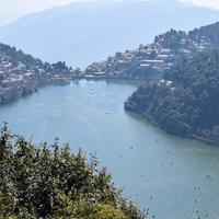 Full view of Naini Lake during evening time near Mall Road in Nainital, Uttarakhand, India, Beautiful view of Nainital Lake with mountains and blue sky photo