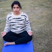 Portrait of gorgeous young Indian woman practicing yoga outdoor in a park. Beautiful girl practice basic yoga pose. Calmness and relax, female happiness. Horizontal orientation photo