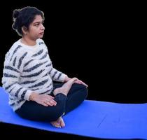 Portrait of gorgeous young Indian woman practicing yoga with plain background. Beautiful girl practice basic yoga pose. Calmness and relax, female happiness photo