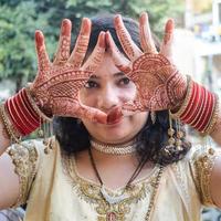 hermosa mujer vestida como tradición india con diseño de henna mehndi en ambas manos para celebrar el gran festival de karwa chauth, celebraciones de karwa chauth de una mujer india para su marido foto