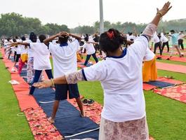 Group Yoga exercise session for people of different age groups at cricket stadium in Delhi on International Yoga Day, Big group of adults attending yoga session photo