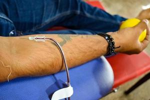 donante de sangre en el campamento de donación de sangre sostenido con una pelota hinchable en la mano en el templo balaji, vivek vihar, delhi, india, imagen para el día mundial del donante de sangre el 14 de junio de cada año, campamento de donación de sangre foto