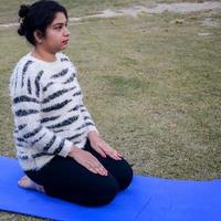 retrato de una hermosa joven india practicando yoga al aire libre en un parque. hermosa chica practica pose básica de yoga. calma y relax, felicidad femenina. orientación horizontal foto