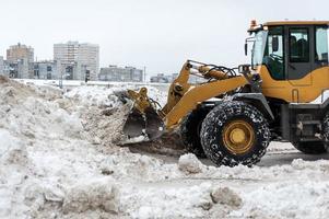 Large dump truck cleans the street from snow photo