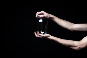 Men's hands with empty jar on black background photo