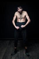 A young man in his pants on a black background photo