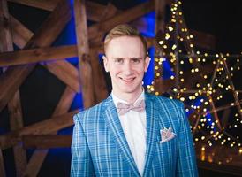 Young man wearing blue blazer and bow tie photo