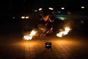 vista borrosa, espectáculo de fuego. los hombres hacen círculos de fuego. fondo borroso foto