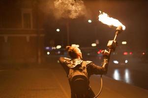 vista borrosa, espectáculo de fuego. los hombres hacen círculos de fuego. fondo borroso foto