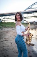 mujer tocando el saxofón al atardecer. foto