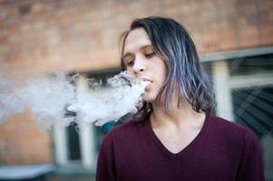 Portrait of a young man in the smoke of cigarettes photo