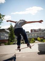 skater hace el truco con un salto en la rampa. skater volando en el aire foto