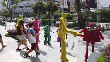 pessoas caminhando por uma instalação de arte na rua video